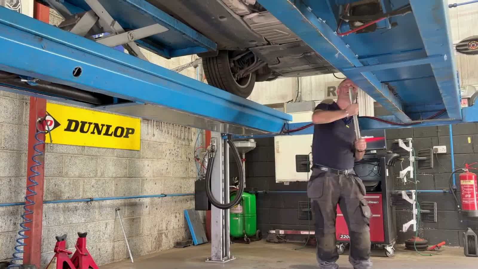 A mechanic working under a car on the lift at Carbery Tyres in Clonakilty